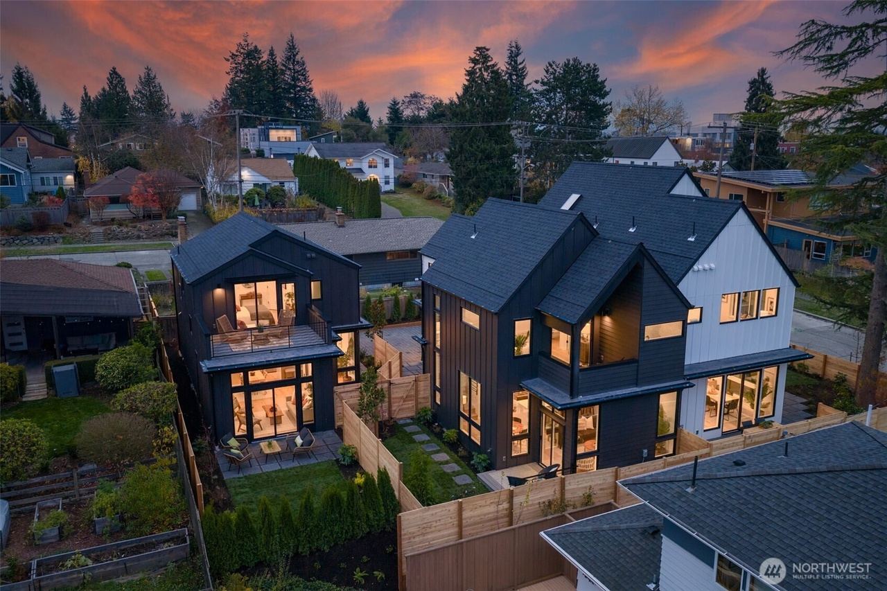 Two-story dark gabled home with a rear terrace and fenced yard
